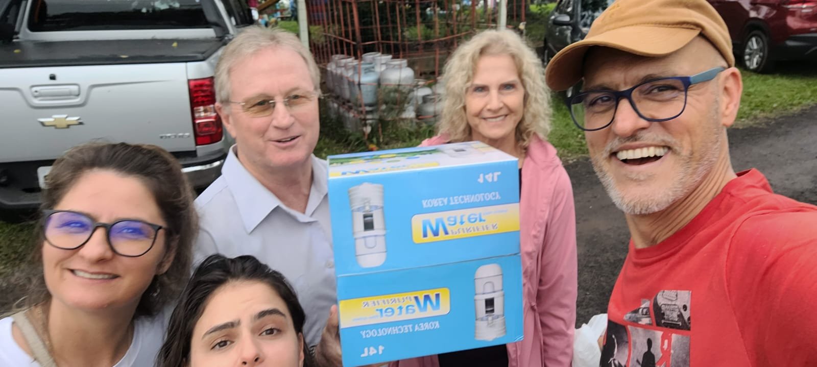Registro compartilhado pela equipe Alimento Água, com pessoas reunidas e uma caixa do produto